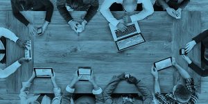 team sat round a desk in a meeting discussing the 7 digital must haves for charities