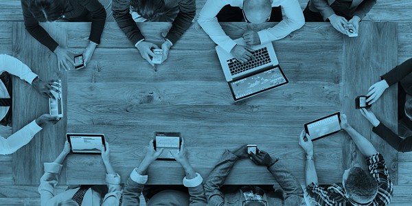 team sat round a desk in a meeting discussing the 7 digital must haves for charities