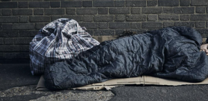 image of someone sleeping on the streets in a sleeping bag homeless