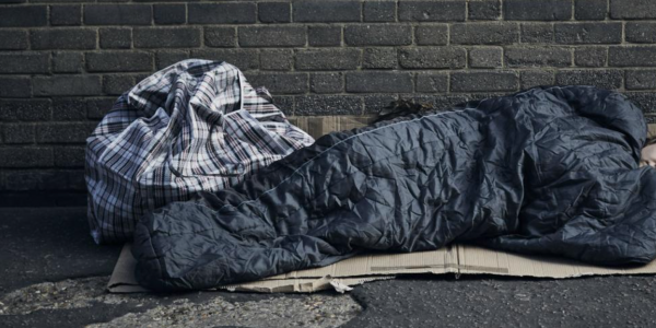 image of someone sleeping on the streets in a sleeping bag homeless